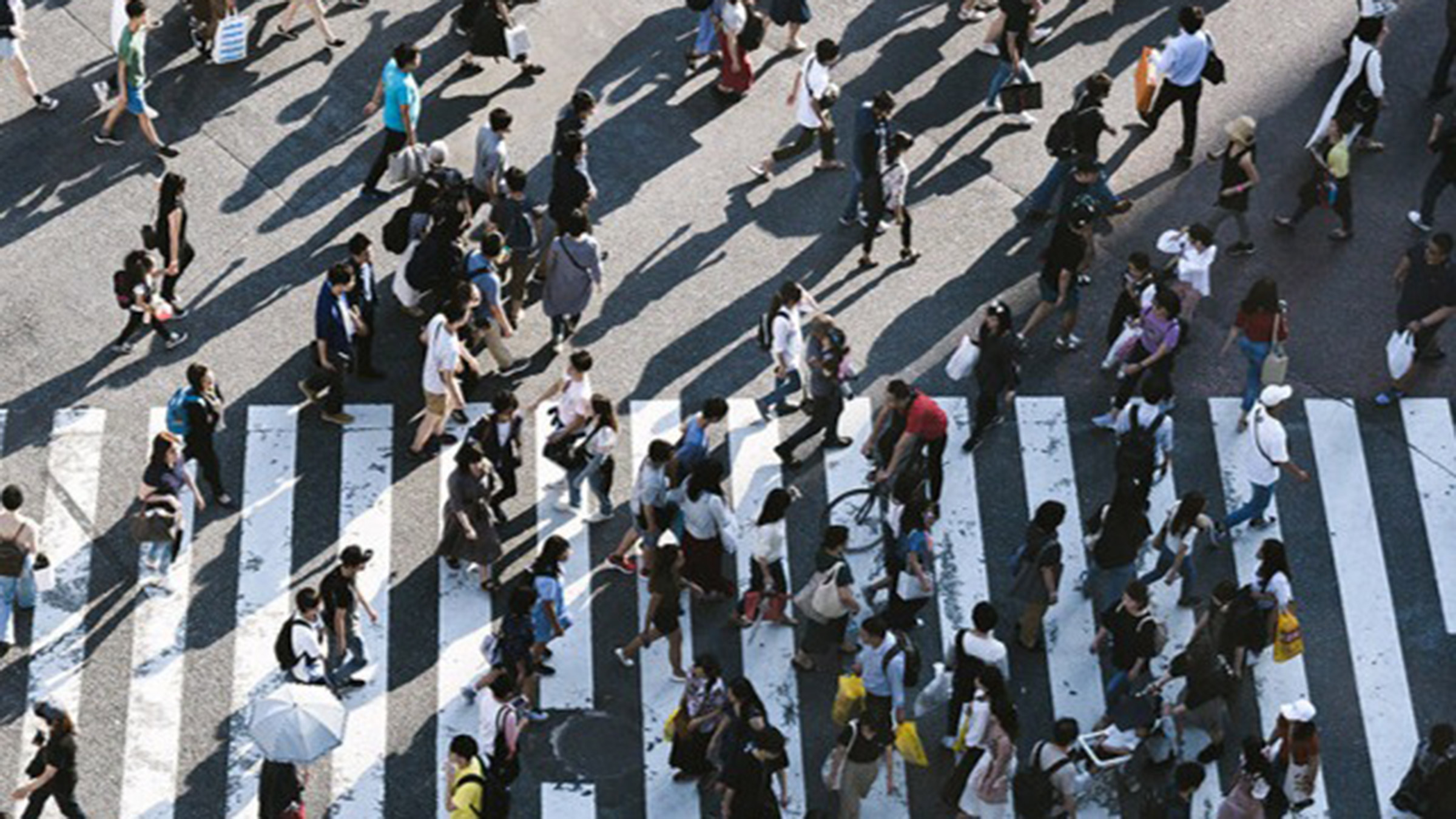 A birds-eye perspective photograph of people crossing a street.